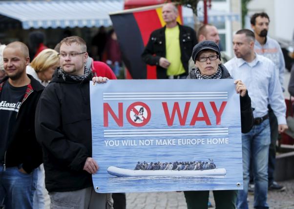 Supporters of the far-right National Democratic Party hold a placard and a German flag during a march in Riesa, Germany