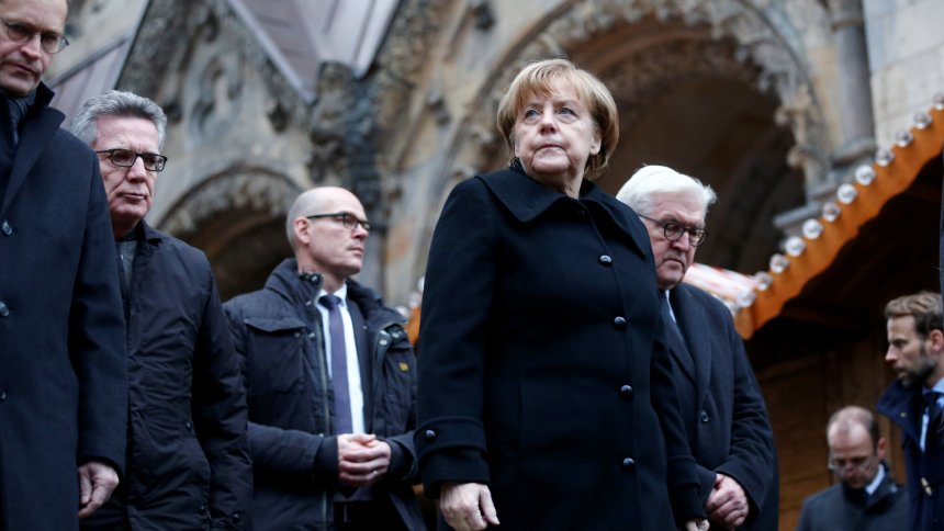 German Chancellor Merkel and German Foreign Minister Steinmeier walk towards the Christmas market in Berlin